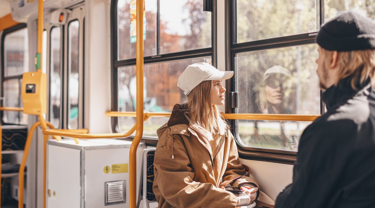 Young beautiful woman looking through the train window. Happy bus passenger traveling sitting in a seat and looking through the window. Young beautiful woman looking through the train window. Happy bus passenger traveling sitting in a seat and looking through the window.