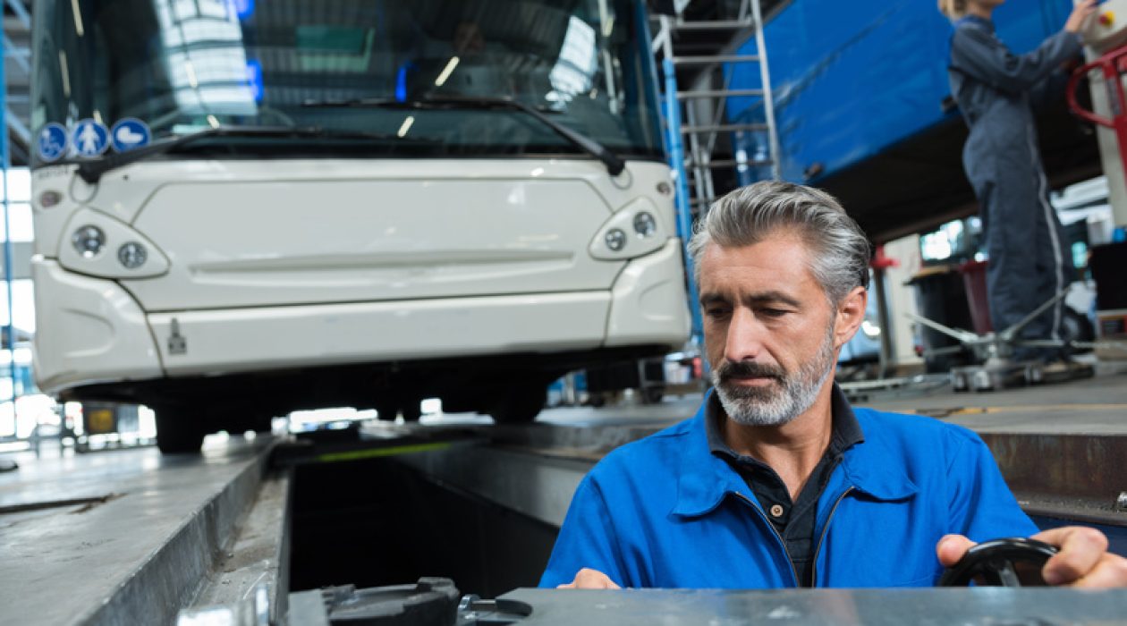man working in bus garage